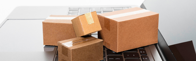 Cardboard boxes on a laptop, representing shipping costs for returning products